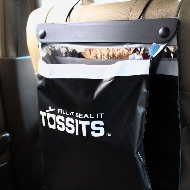 A full Tossits bag on the headrest, ready to seal and tear off