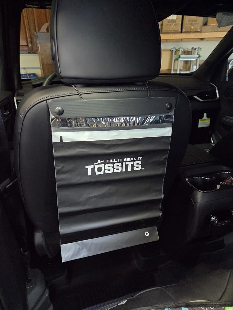 Black Tossits bag hanging on a seat back, photographed by customer Anesa Z.