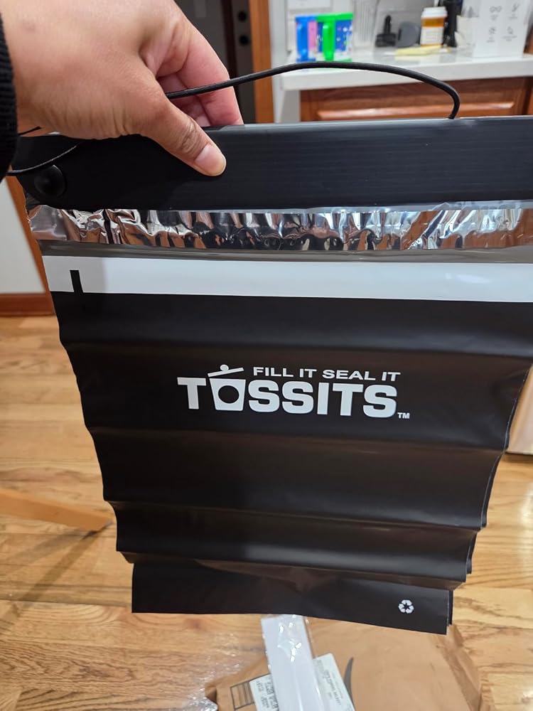 Black Tossits bag held in hand, photographed by customer Anesa Z.
