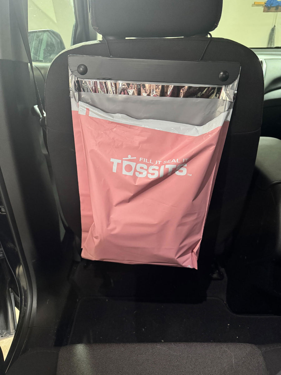 Pink Tossits bag hanging behind a seat, photographed by customer Emilia Y.